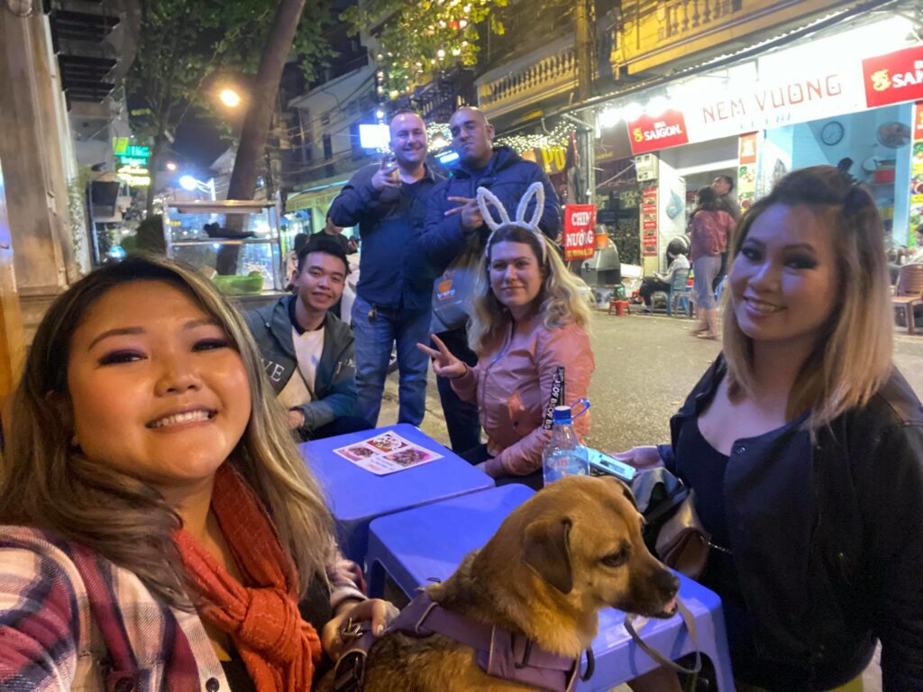 a woman holding a dog posing for the camera