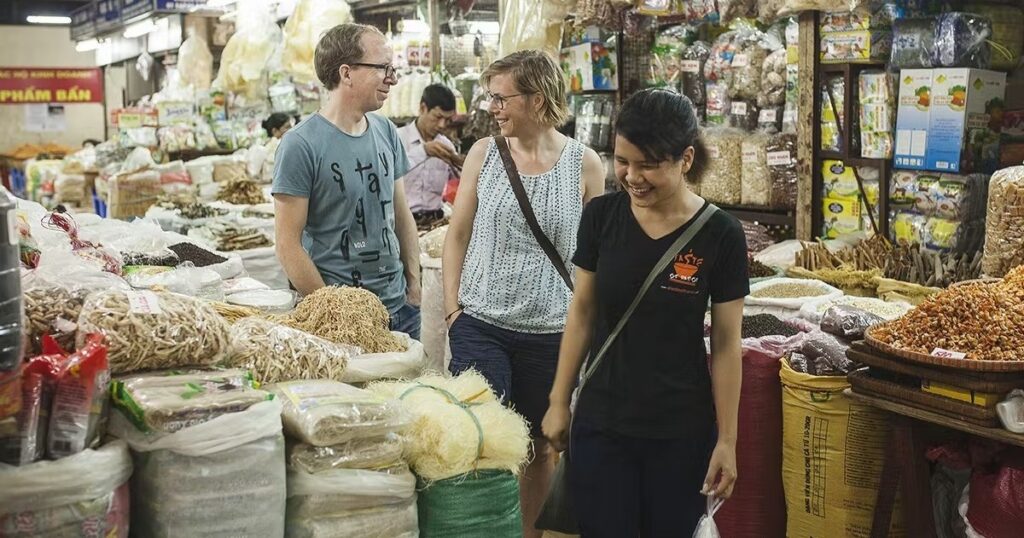 a person standing in front of a store filled with lots of fresh produce