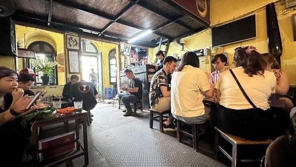 People sitting in a cozy, yellow-walled cafe with a rustic interior.